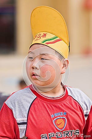 Overweight Chinese boy with a funny hat, Beijing, China Editorial Stock Photo